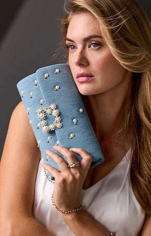 Model is wearing denim with pearl detailing clutch